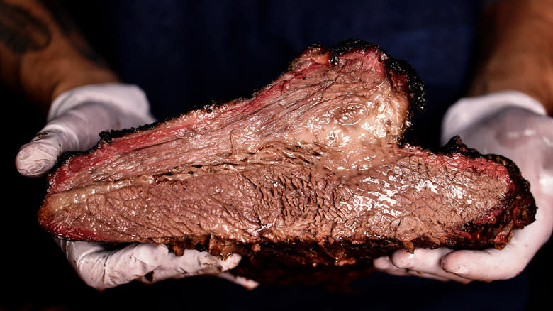 butcher holding cooked steak