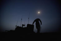 <p>PVT Jay Mora, of Quebec, Canada, with the Canadian Army’s 1st Battalion 22nd Royal Regiment, dismounts from a light armored vehicle under the moonlight in preparation for an operation, June 26, 2011 at Forward Operating Base Kyhber in the Panjwaii district of Kandahar province, Afghanistan. (AP Photo/David Goldman) </p>