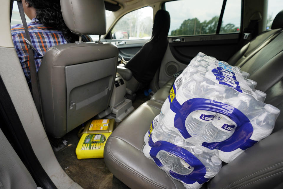 Cases of water rest on the back seat of Carey Wooten's car at a drive-thru water distribution site in Jackson, Miss., part of the community's efforts to deal with the city's longstanding water issues, Sept. 7, 2022. A boil-water advisory has been lifted for Mississippi's capital, and the state will stop handing out free bottled water on Saturday. But the crisis isn't over. Water pressure still hasn't been fully restored in Jackson, and some residents say their tap water still comes out looking dirty and smelling like sewage. (AP Photo/Rogelio V. Solis)