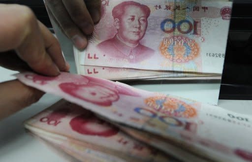 A Chinese bank worker counts a stack of 100-yuan notes at a bank in Hefei, 2011. China's central bank announced it had cut interest rates for the second time in a month, the latest measure by authorities to boost growth in the world's second-biggest economy