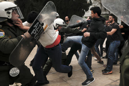 Greek Communist Party supporters clash with police as they try to bring down a statue of former U.S. President Harry Truman during a demonstration against air strikes on Syria by the United States, Britain and France, in Athens, Greece, April 16, 2018. REUTERS/Alkis Konstantinidis