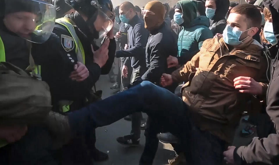 In this image from video provided by Radio Free Europe/Radio Liberty, far-right demonstrators clash with riot police outside the presidential administration building in Kiev, Ukraine, Saturday, March 9, 2012. Three police officers in Ukraine have been injured in a clash with far-right demonstrators in the capital. The violence occurred outside the presidential administration building in Kiev where several hundred demonstrators had gathered Saturday to call for arrests of top figures in an alleged military corruption scandal. (Radio Free Europe/Radio Liberty via AP)