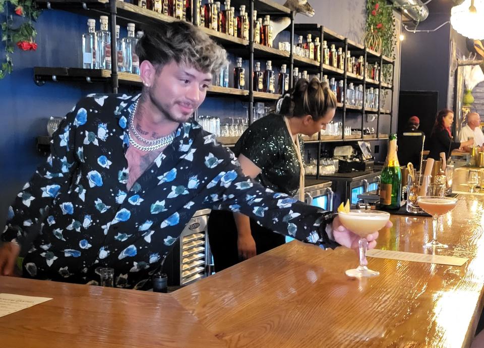 Michael Stover, of Renaissance Man Distillery and Cocktail Lounge, passes a cocktail across the counter on Wednesday, July 5, 2023, on the business' first day open in downtown Port Huron.