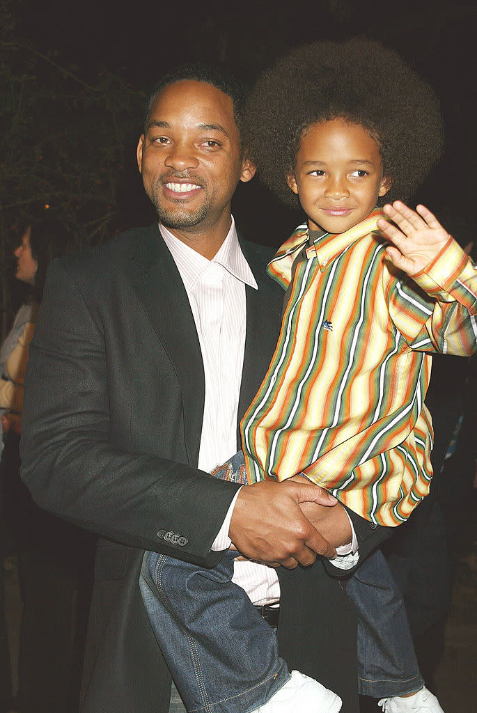 he's being carried by his dad will smith at an event
