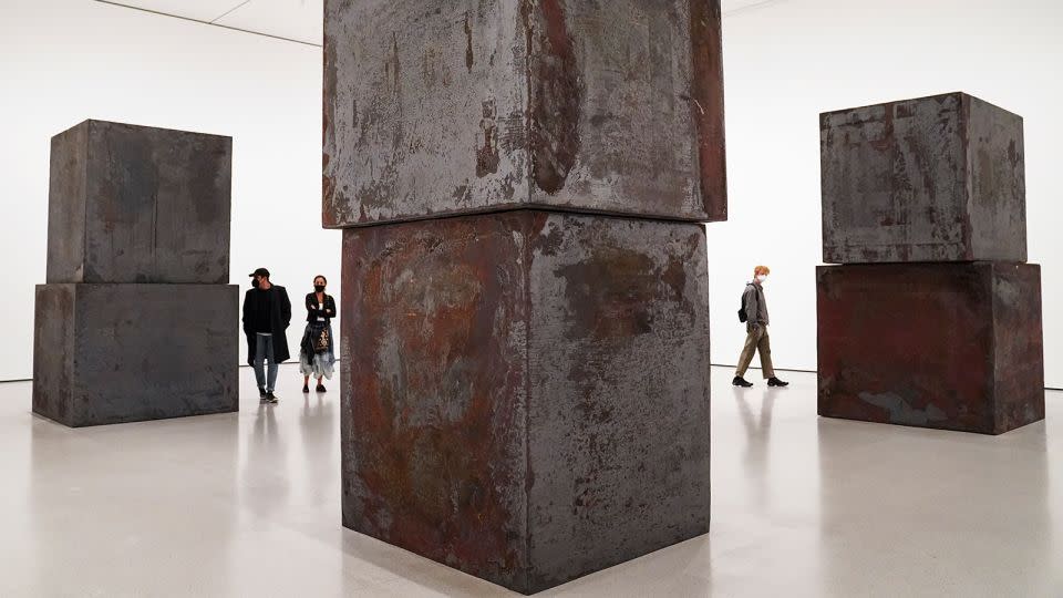 Museum visitors walk among the cubic forms of Serra's sculpture "Equal" at the Museum of Modern Art in New York in 2020. - John Minchillo/AP