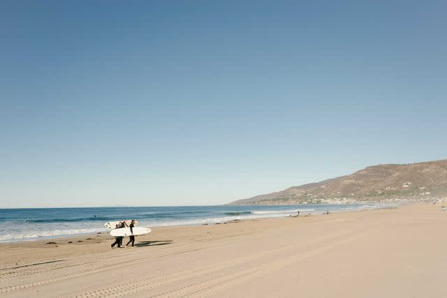 <p>Carmen Chan</p> Surfers on Zuma Beach, in Malibu, California.