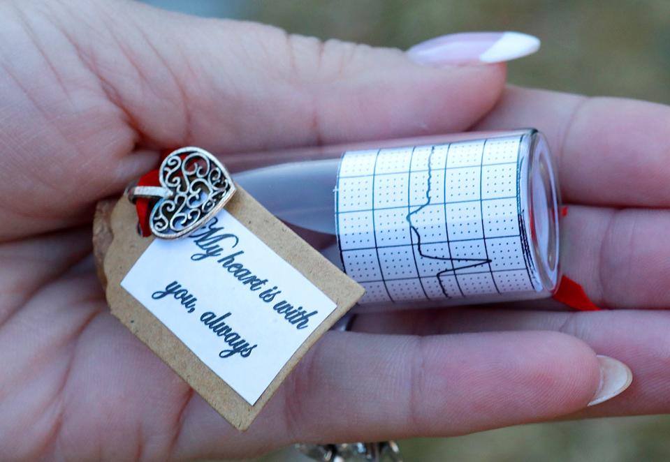 Lara Brait, of Marshfield, holds a vial with a printout showing a departed loved one's last heartbeat Friday, Feb. 10, 2023.