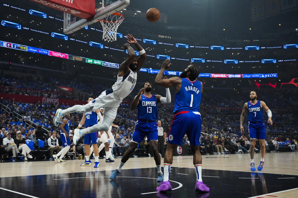 Dallas Mavericks guard Kyrie Irving (11) loses control of the ball during the first half of Game 1 of an NBA basketball first-round playoff series against the LA Clippers in Los Angeles, Sunday, April 21, 2024. LA Clippers forward Paul George (13) and guard James Harden (1) defend. (AP Photo/Ashley Landis)