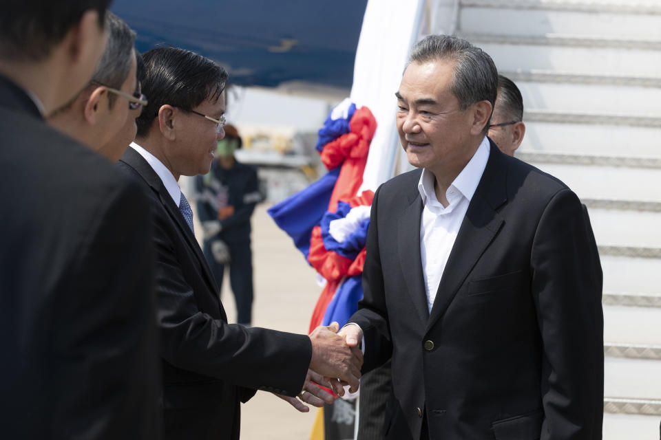 China's Foreign Minister Wang Yi, right, arrives at Wattay International Airport in Vientiane, Laos, Wednesday, Feb. 19, 2020. The foreign ministers of Association of Southeast Asian Nations are meeting in Laos Thursday to discuss ways to curb the spread of the new virus infections. (AP Photo/Sakchai Lalit)