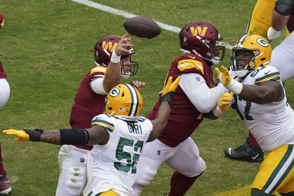 Washington Commanders quarterback Taylor Heinicke (4) throws under pressure from Green Bay Packers linebacker Rashan Gary (52) during the first half of an NFL football game Sunday, Oct. 23, 2022, in Landover, Md. (AP Photo/Al Drago)