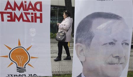 A woman walks past a poster for Turkey's Prime Minister Tayyip Erdogan's election campaign in Istanbul March 27, 2014. REUTERS/Osman Orsal