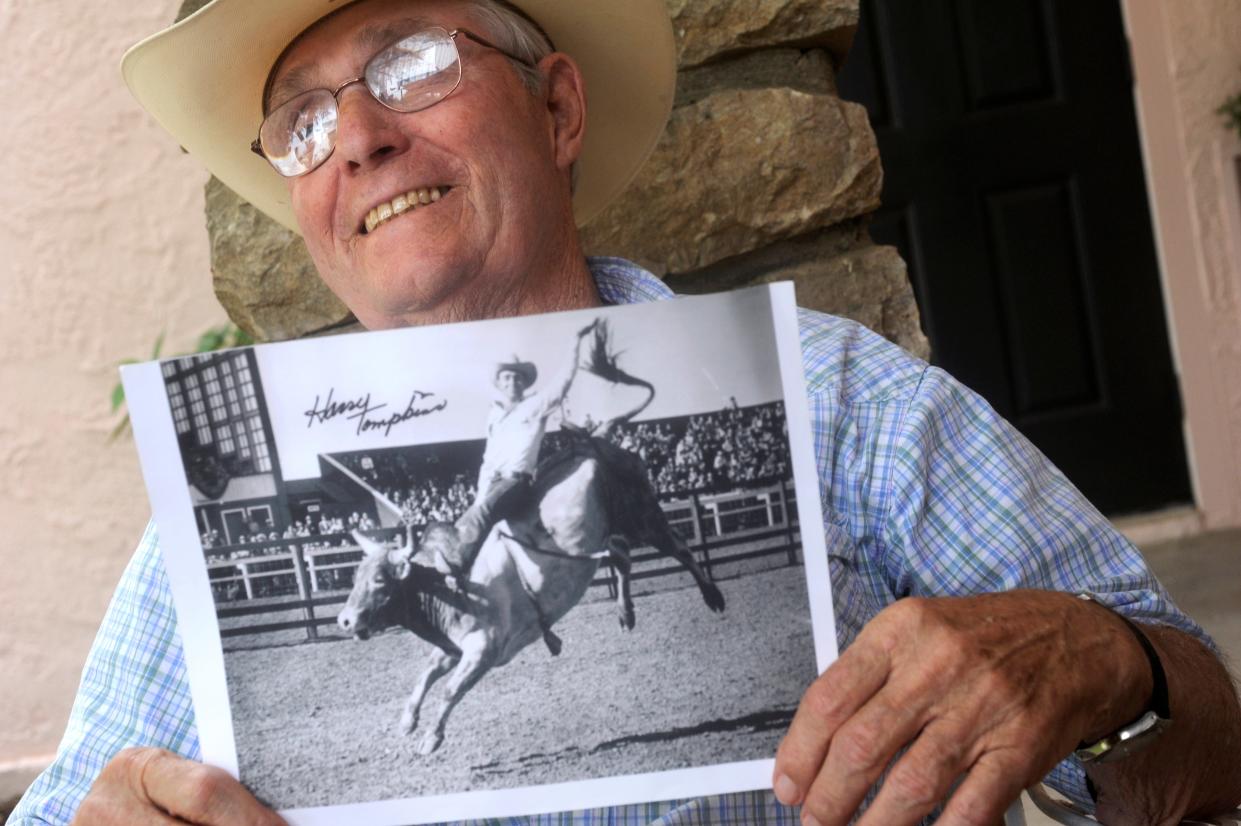 Harry Tompkins holds a copy of a photograph of him by DeVere Helfrich riding a bull in 1949 and laughs while reminiscing over his memories as a bullriding champion in 2011. Tompkins, who died in 2018, is one of many honored in Dublin's Rodeo Heritage Museum.