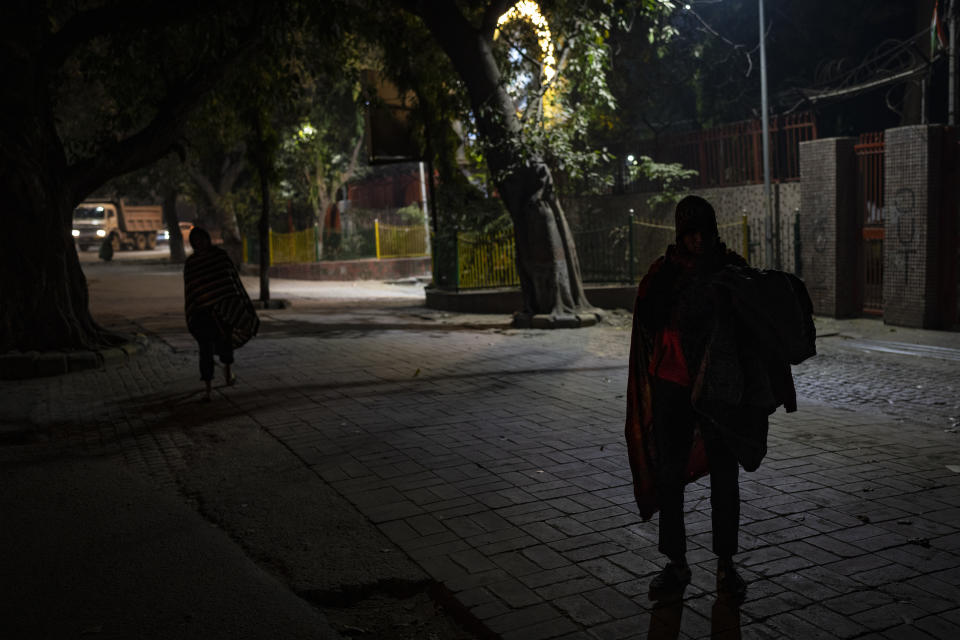 Homeless people wait to be transported to a night shelter on a cold night in New Delhi, Thursday, Dec. 29, 2022. The city’s 195 homeless shelters can accommodate only about 19,000 people, leaving tens of thousands struggling to keep warm. The harsh winter is blamed for killing scores of homeless people. (AP Photo/Altaf Qadri)