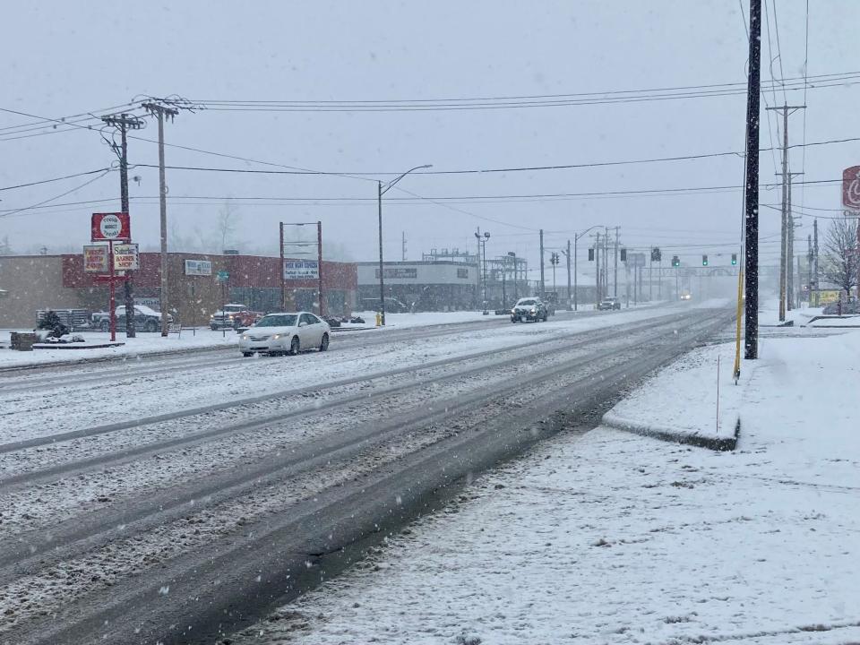 Sparse traffic moves slowly on McGalliard Road Wednesday morning as a winter storms dumps snow on Muncie. The city was forecast to receive about 5 inches of snow from the storm.