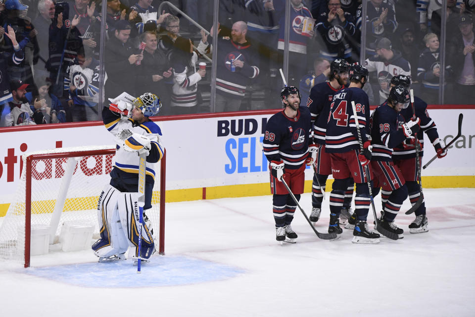 Winnipeg Jets celebrate after their third goal as St. Louis Blues goaltender Thomas Greiss (1) has a drink during the third period of NHL hockey game action in Winnipeg, Manitoba, Monday, Oct. 24, 2022. (Fred Greenslade/The Canadian Press via AP)
