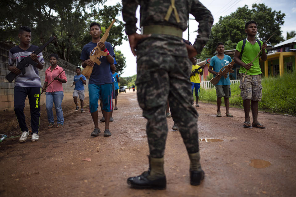 En esta fotografía del 5 de septiembre de 2018, estudiantes son supervisados por un soldado del Ejército hondureño mientras practican su rutina para un desfile militar en Puerto Lempira, Honduras. (AP Foto/Rodrigo Abd)