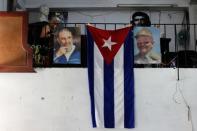 The Cuban flag hangs next to the photographs of late Cuba's President Fidel Castro and his brother, Cuba's former President Raul Castro, in Havana, Cuba July 21, 2018. REUTERS/Stringer