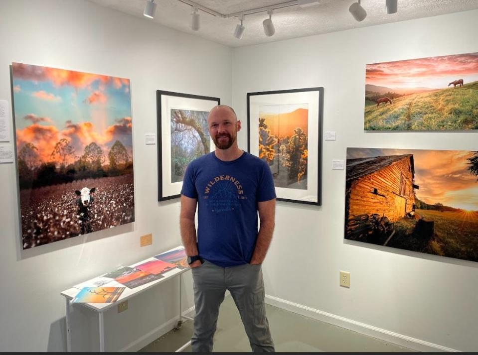 Chris Greer stands in a section of his studio showing the various canvases that photos are offered.