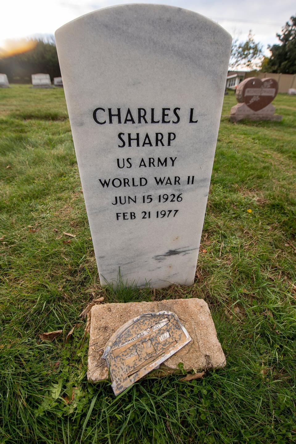A new stone for World War II veteran Charles L. Sharp rises above the buried marker that marked his final resting place for decades.