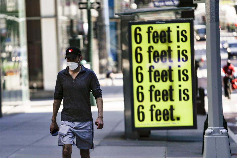 A pedestrians wears a protective mask during the coronavirus pandemic Friday, May 15, 2020, in New York.