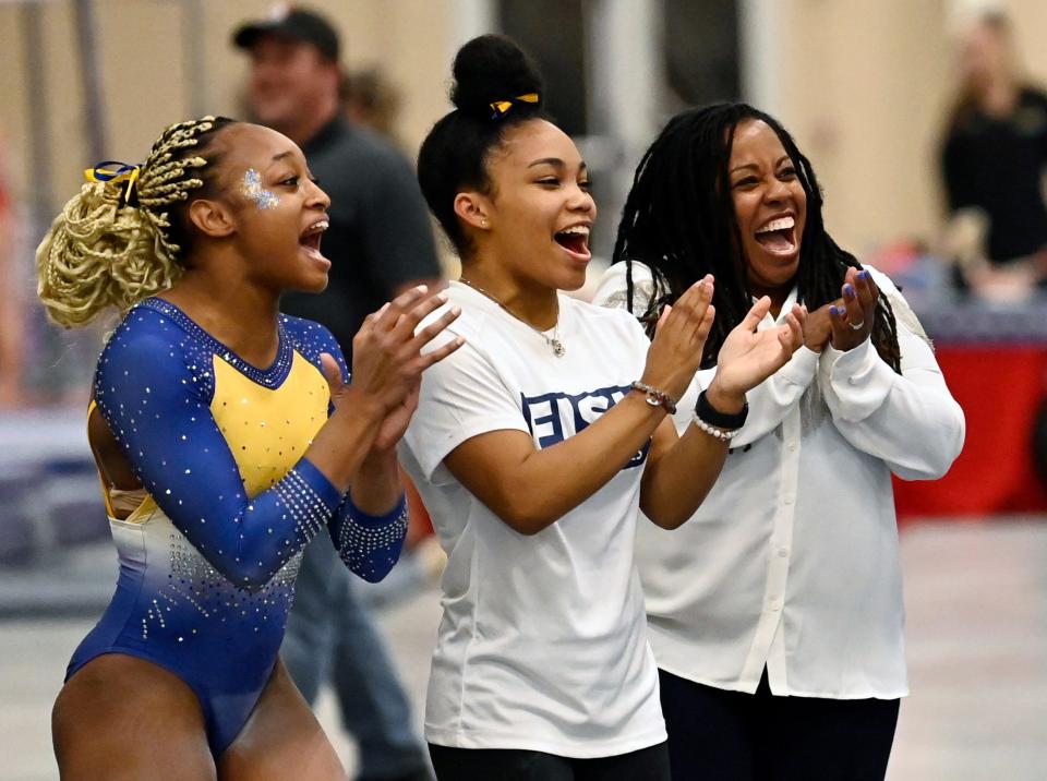Fisk University gymnast Naimah Muhammad, left, Kiana Session and head coach Corrinne Tarver cheer during the Tennessee Collegiate Classic meet Friday, Jan. 20, 2023, in Lebanon, Tenn. Fisk is the first historically Black university to have an intercollegiate women’s gymnastics team.
