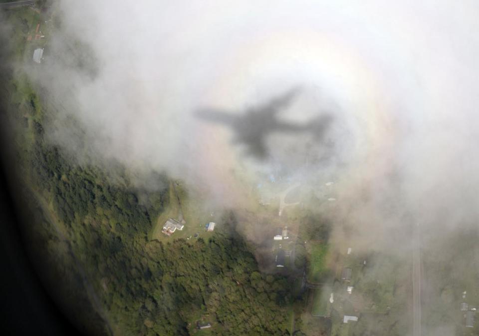 The shadow of Air Force One, with President Barack Obama aboard, is seen on a cloud as it approaches Paine Field Airport, Tuesday, April 22, 2014, in Everett, Wash., en route to Oso, Wash., the site of the deadly mudslide that struck the community in March. (AP Photo/Carolyn Kaster)