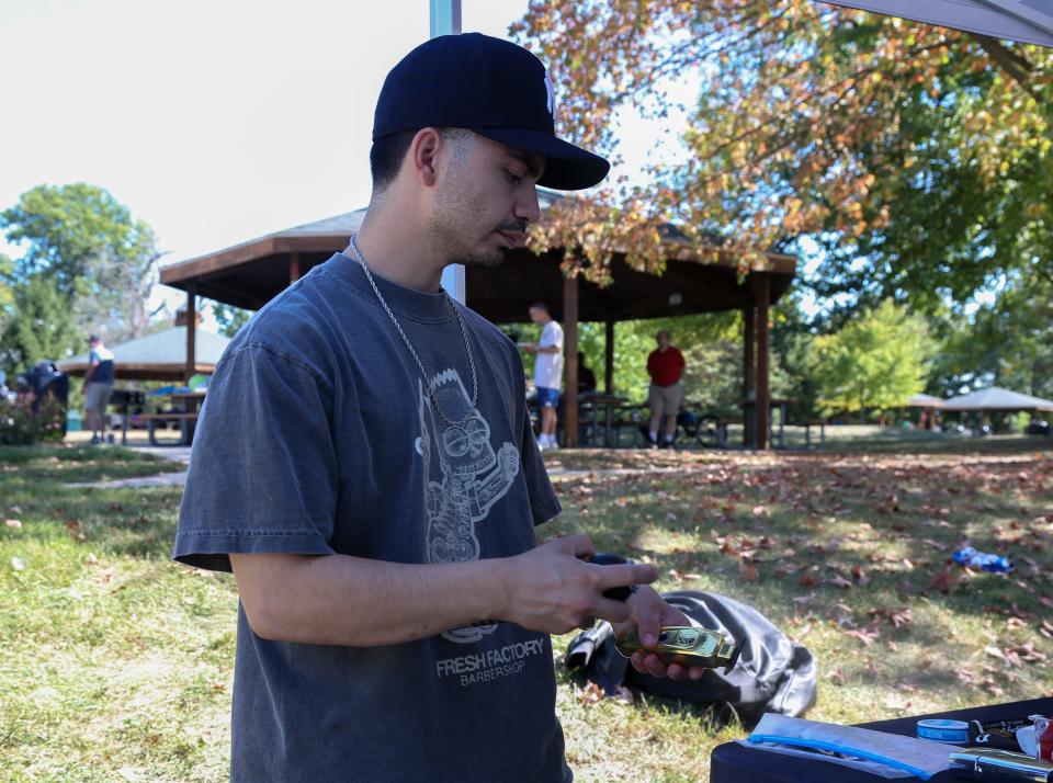 Kevin Vargas, owner of Fresh Factory Barbershop in Lafayette, cleans his hair clippers at the 2023 Tippecanoe Latino Festival, on Saturday, Sept. 23, 2023, in Lafayette, Ind.