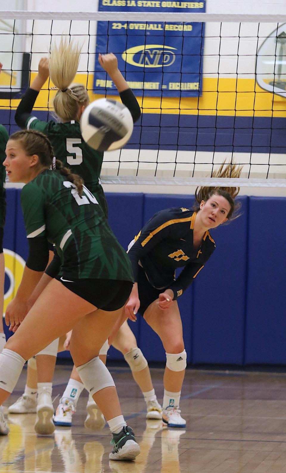 Notre Dame's Gabby Deery (11) watches as her spike goes through West Burlington's Lauren Glasgow (5) and Abbey Bence (20) Tuesday in Burlington.