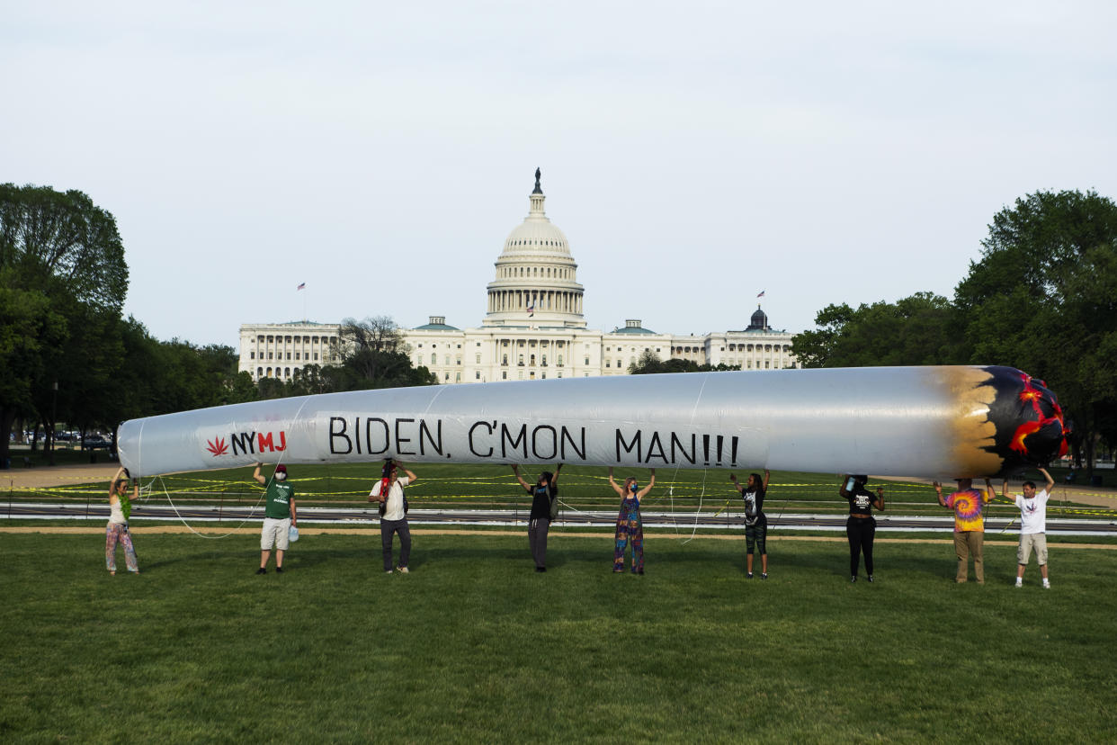 Members of the DC Marijuana Justice community hold a 51 blow-up joint on the National Mall ahead of President Joe Bidens address to a joint session of Congress to call on the administration to take action on legalization and expungement of criminal records on Wednesday, April 28, 2021. (Tom Williams/CQ-Roll Call, Inc via Getty Images)