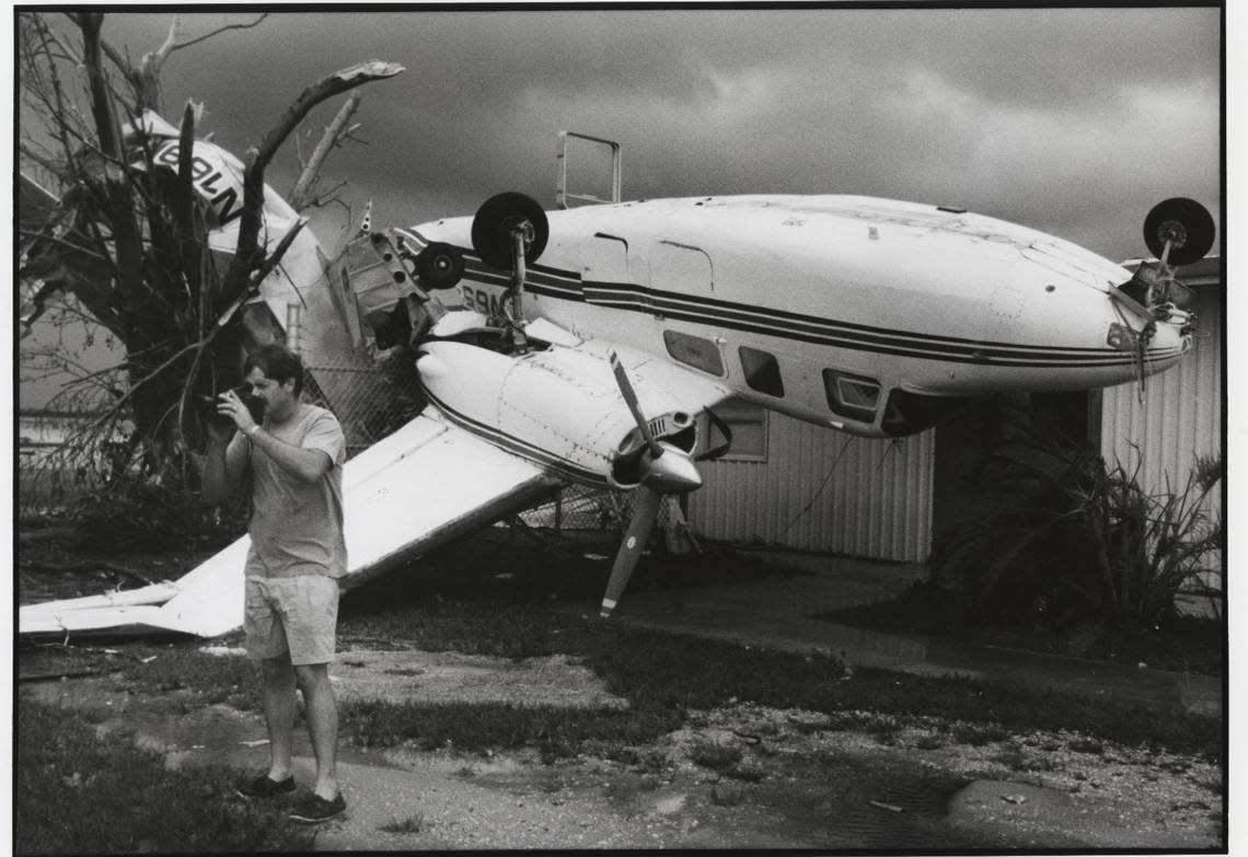 Preston Brock videotapes damage to planes at his friend Bud Skinner’s airplane hanger at Tamiami Airport in this file photo from August 1992, soon after Hurricane Andrew devastated South Miami-Dade.