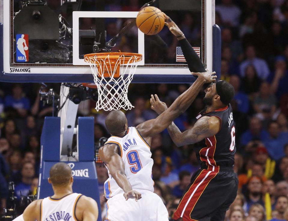 Miami Heat forward LeBron James (6) dunks in front of Oklahoma City Thunder forward Serge Ibaka (9) during the fourth quarter of an NBA basketball game in Oklahoma City, Thursday, Feb. 20, 2014. James fell to the floor with a bloody nose. Miami won 103-81. (AP Photo/Sue Ogrocki)