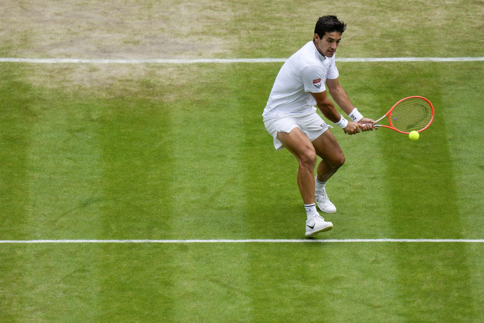 Chile's Cristian Garin returns the ball to Australia's Nick Kyrgios during a men's singles quarterfinal match on day ten of the Wimbledon tennis championships in London, Wednesday, July 6, 2022. (AP Photo/Alastair Grant)