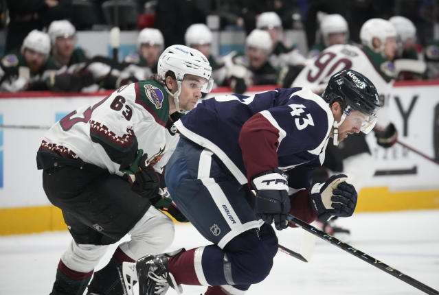 Colorado Avalanche center Darren Helm, right, chases after the puck with Arizona Coyotes left wing Matias Maccelli in the second period of an NHL hockey game Friday, March 24, 2023, in downtown Denver. (AP Photo/David Zalubowski)