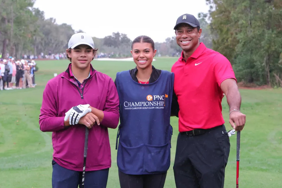 Dec 17, 2023; Orlando, Florida, USA; Charlie Woods (left) and Tiger Woods (right) pose for a family photo with Sam Woods on the first tee during the PNC Championship at The Ritz-Carlton Golf Club. Mandatory Credit: Reinhold Matay-USA TODAY Sports