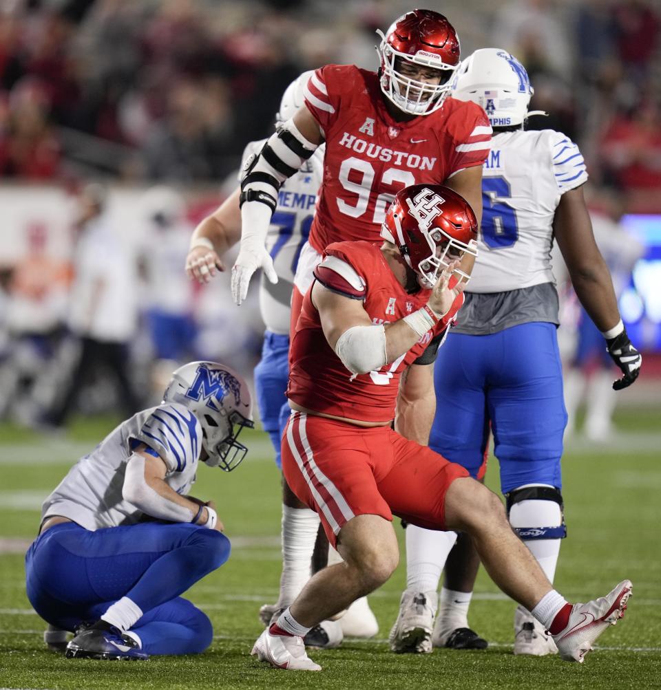 Houston defensive lineman Derek Parish, right front, celebrates his sack of Memphis quarterback Seth Henigan, left, during the second half of an NCAA college football game Friday, Nov. 19, 2021, in Houston. (AP Photo/Eric Christian Smith)