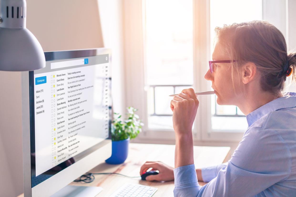 Female business person reading email on computer screen at work on internet