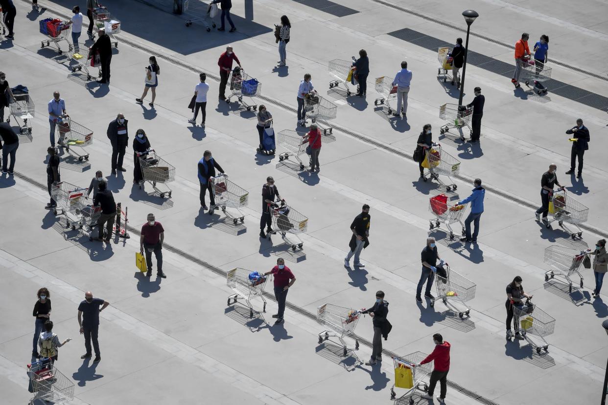 People stand in long lines waiting to enter at the Esselunga supermarket in San Donato, in the outskirts of Milan, Italy, on Saturday, April 11.