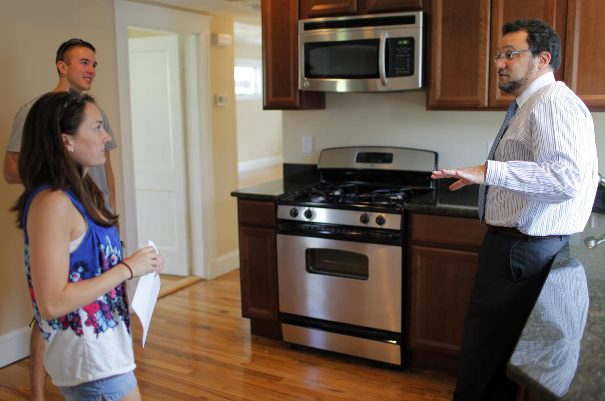 Realtor Steve Bremis (R) talks to house hunters Makayla Gavitt (L) and David Harris during an open house at a condominium unit in Somerville, Massachusetts May 16, 2010. U.S. housing starts rose more than expected in April to touch their highest level since October 2008 likely on the back of a home buyer tax credit, but permits hit a six-month low, a government report showed on May 18, 2010. Picture taken May 16, 2010. REUTERS/Brian Snyder    (UNITED STATES - Tags: BUSINESS)