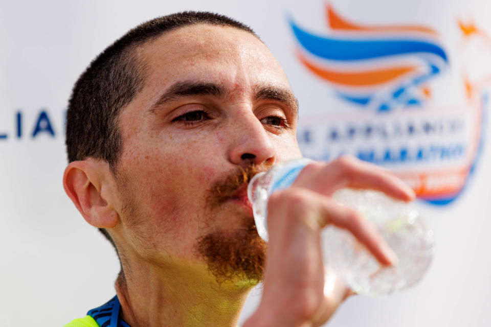 Antonio Marchi drinks water after finishing first in the full marathon during the 2022 Kentucky Derby Festival mini Marathon and full marathon on Saturday, April 30, 2022, at Lynn Family Stadium in Louisville, Kentucky.
