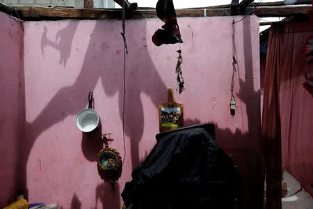 The shadow of a man is casted on a wall as he fixes the roof of a house damaged by Hurricane Matthew in Les Cayes, Haiti, October 5, 2016. REUTERS/Andres Martinez Casares