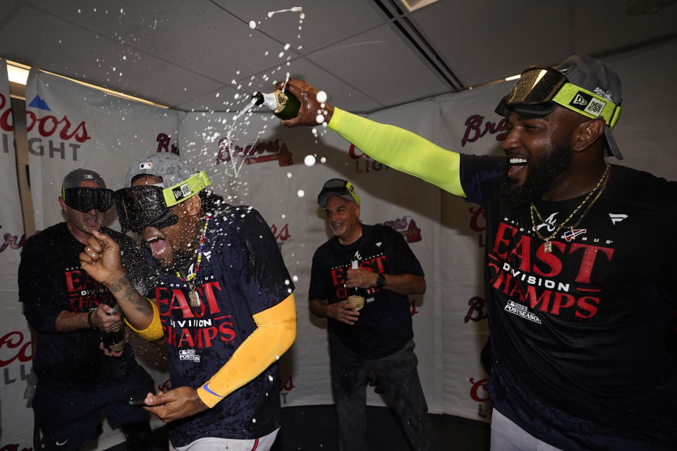 Atlanta Braves' Ronald Acuna Jr., left, celebrates with Marcell Ozuna after the Braves clinched their sixth consecutive NL East title by defeating the Philadelphia Phillies in a baseball game, Wednesday, Sept. 13, 2023, in Philadelphia. (AP Photo/Matt Slocum)
