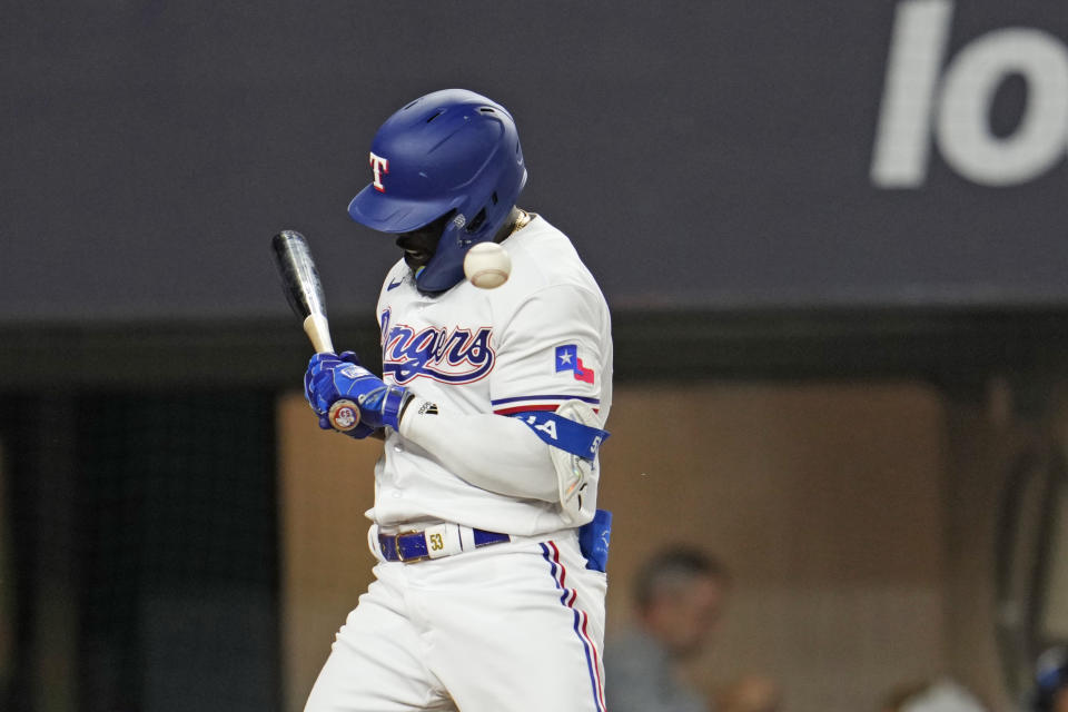 Texas Rangers' Adolis Garcia is hit by a pitch thrown by Houston Astros' Bryan Abreu during the eighth inning in Game 5 of the baseball American League Championship Series Friday, Oct. 20, 2023, in Arlington, Texas. (AP Photo/Godofredo A. Vásquez)