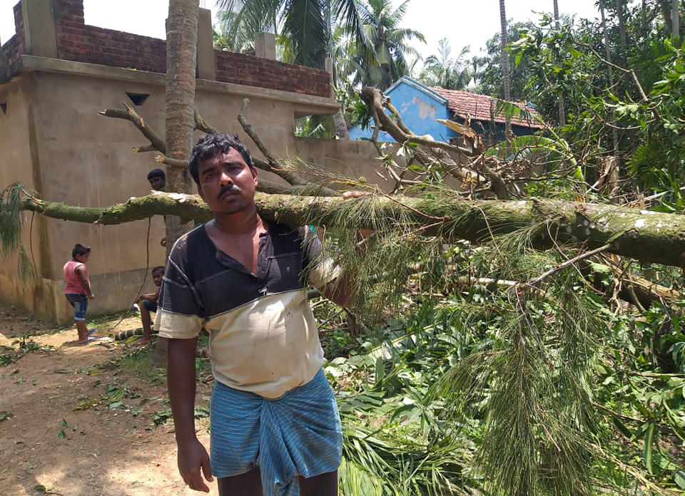 A villager clears tree branches fallen in front of his house after Cyclone Amphan hit the region, at Baguranjalpai village in East Midnapore district in West Bengal state, India, Friday, May 22, 2020. People forgot about social distancing and crammed themselves into government shelters, minutes before Cyclone Amphan crashed in West Bengal. The cyclone killed dozens of people and the coronavirus nine in this region, one of India’s poorer states. Even before the cyclone, its pandemic response was lagging; the state has one of the highest fatality rates from COVID-19 in India. With an economy crippled by India’s eight-week lockdown, and health care systems sapped by the virus, authorities must tackle both COVID-19 and the cyclone’s aftermath.(Debasis Shyamal via AP)