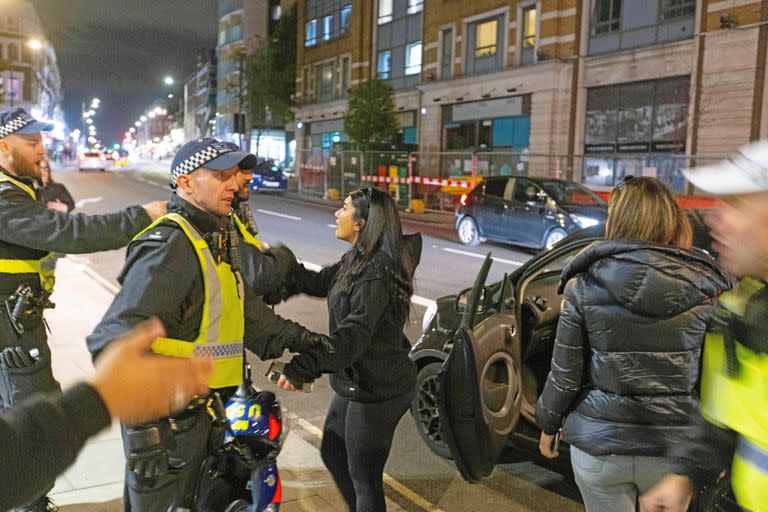 Agentes de policía piden a los manifestantes que abandonen la zona tras los enfrentamientos con la policía frente al Centro Islámico de Kilburn, en Londres, el 25 de septiembre de 2022. 