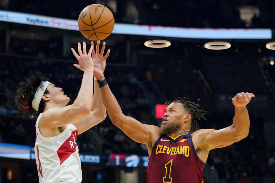 Toronto Raptors guard Yuta Watanabe, left, and Cavaliers guard Justin Anderson battle for a loose ball in the first half of the Cavs' 144-99 win Sunday night in Cleveland. [Tony Dejak/Associated Press]