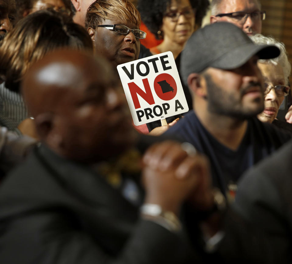 In this photo taken Tuesday, July 31, 2018, people opposing Proposition A listen to a speaker during a rally in Kansas City, Mo. Missouri votes Tuesday, Aug. 7 on a so-called right-to-work law, a voter referendum seeking to ban compulsory union fees in all private-sector workplaces. (AP Photo/Charlie Riedel)