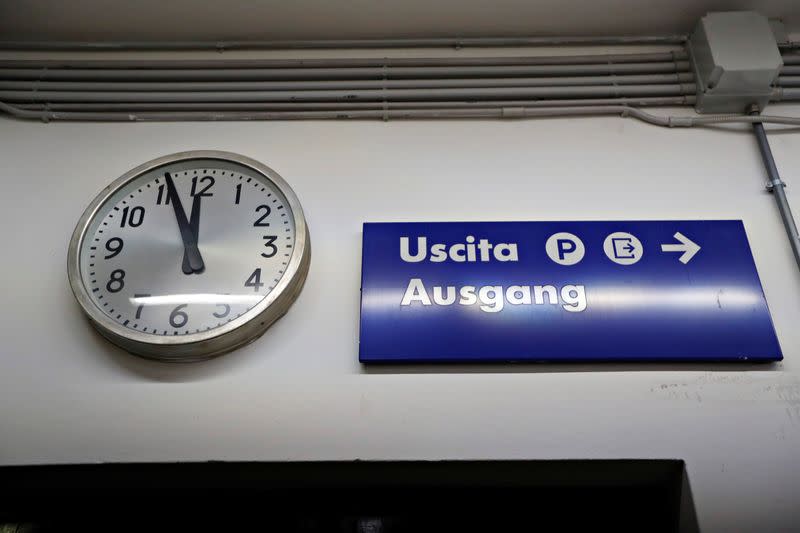 A clock and a sign are seen at the Brennero-Brenner train station in Italy