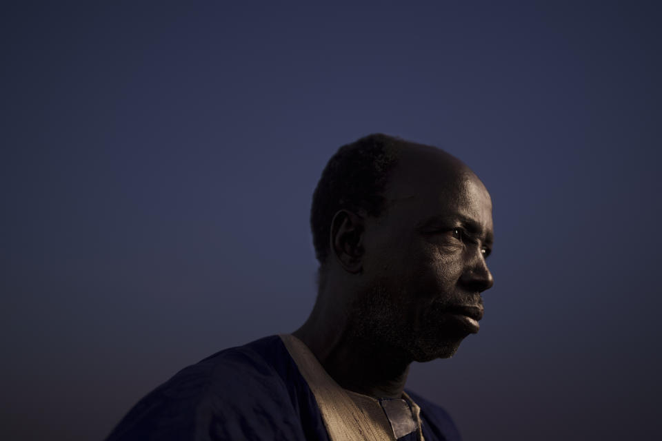 Oumar Koume, whose son Djibi Koume went missing as he tried to reach Spain's Canary Islands by boat, poses for a portrait in the village of Moudji, near Selibaby, Mauritania, Tuesday, Dec. 7, 2021. An AP investigation has found that the younger Koume was among 43 people to have boarded the boat that was found in Tobago on May 28, 2021 more than four months after its departure from Mauritania. (AP Photo/Felipe Dana)