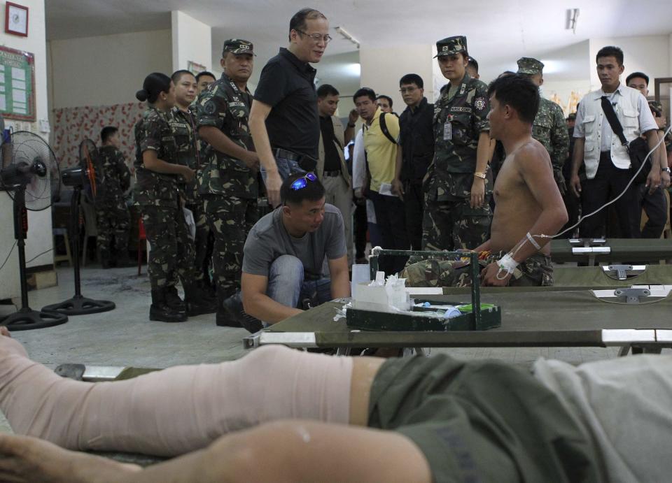 Philippine President Benigno Aquino speaks to a wounded soldier during a visit to assess the situation of the standoff between the Moro National Liberation Front (MNLF) and government forces, at the Camp Navarro hospital in Zamboanga city