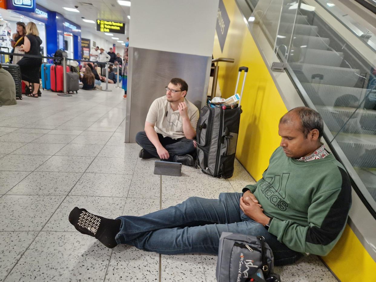 Passengers sit and wait at London Gatwick Airport, Crawley, east Sussex, following delays amid reports of widespread IT outages affecting airlines, broadcasters and banks. Picture date: Friday July 19, 2024.